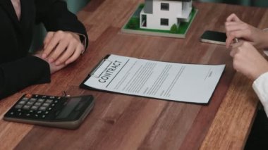 Gayretli emlak acentesi müşteriye bir emlak acentesi tarafından tavsiye edilirken, ev kredisi için müşteri sözleşmesi belgelerini sunar..