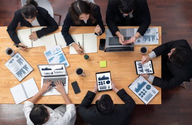 Top-view business team of financial data analysis meeting with business intelligence, report paper and dashboard on laptop for marketing strategy. Business people working together in office of harmony