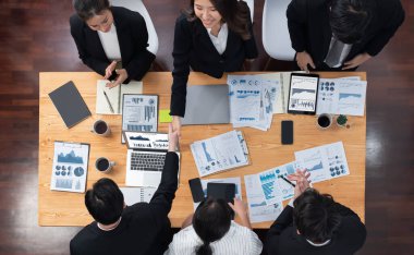 Top-view business team of financial data analysis meeting with business intelligence, report paper and dashboard on laptop for marketing strategy. Business people working together in office of harmony