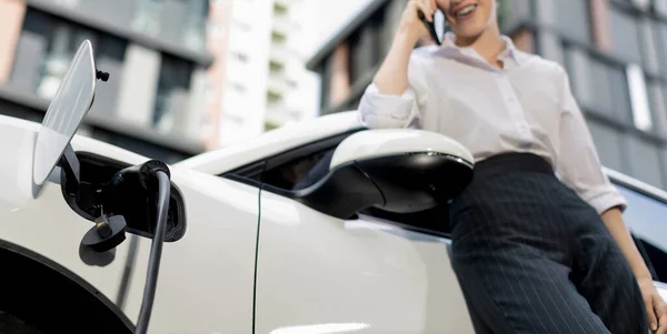 Focus Charging Electric Car Charger Charging Station Blur Businesswoman Talking — Foto de Stock