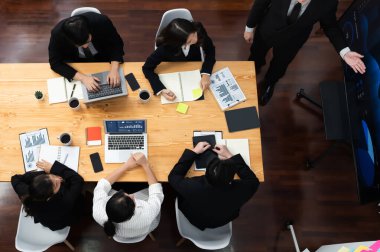 Top view manager or office worker give presentation in harmony conference room to business colleague, BI data dashboard on screen and pile of financial analyzed data reports on meeting table.