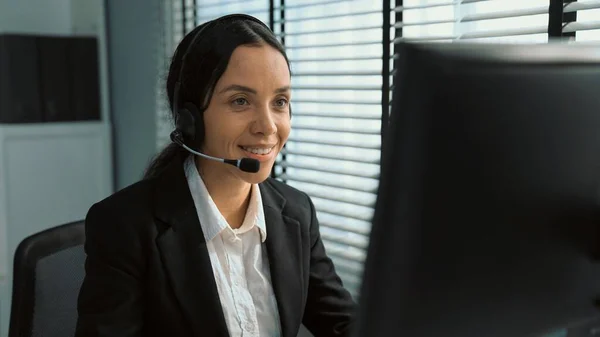 stock image Competent female operator working on computer and talking with clients. Concept relevant to both call centers and customer service offices.