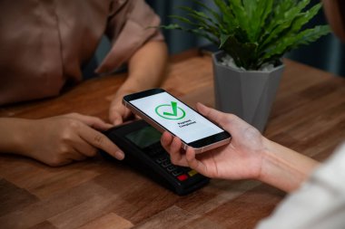 QR kodu parasız ödeme taraması için ekranda gösterilir. Kapalı eller, mobil uygulamadan elektronik işlem yoluyla para aktarmak için akıllı telefonu tutuyor. Hızlı ödeme için barkod teknolojisi. Coşkulu.