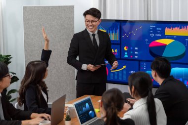 Confidence and asian businessman give presentation on financial analyzed by business intelligence in dashboard report to other people in board room meeting to promote harmony in workplace.