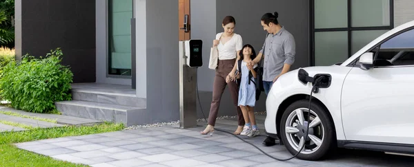 Progressive Young Parents Daughter Electric Vehicle Home Charging Station Green — Φωτογραφία Αρχείου