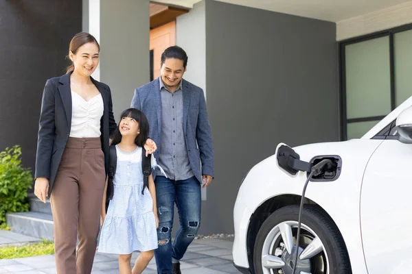 Progressive Young Parents Daughter Electric Vehicle Home Charging Station Green — ストック写真
