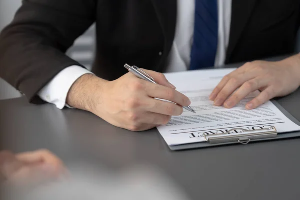 stock image Businessman signs contract agreement paper or business legal form with trust and professionalism. Closeup of hand holding pen in corporate meeting for official business deal. Equilibrium