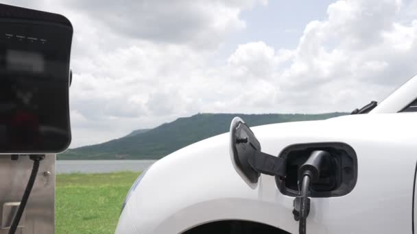 Postępowa Koncepcja Pojazdu Elektrycznego Samochód Wraz Stacją Ładowania Naturalne Tło — Wideo stockowe