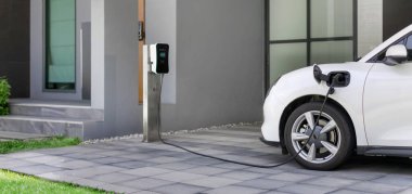 Yeşil çevre için sıfır CO2 emisyonu olan sürdürülebilir ve temiz enerjiyle çalışan EV araba ve ev şarj istasyonu konsepti. Elektrikli taşıtlar için konut alanındaki şarj noktası.