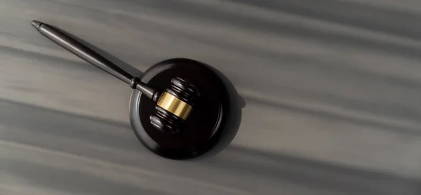 Closeup top view black wooden gavel hammer on wooden office desk background as justice and legal system for lawyer and judge, Legal authority and fairness in trials concept. equility