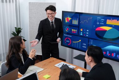 Confidence and asian businessman give presentation on financial analyzed by business intelligence in dashboard report to other people in board room meeting to promote harmony in workplace.