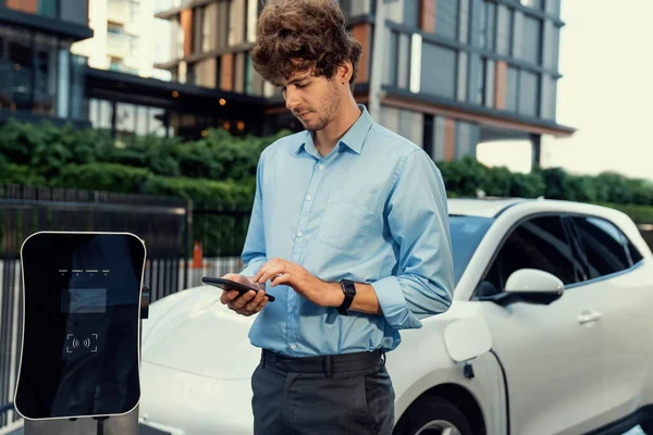 Suit Clad Progressive Businessman Look Cars Battery Status His Phone — Foto de Stock