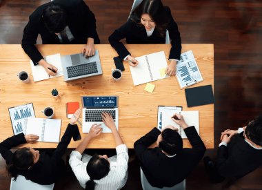 Top view manager or office worker give presentation in harmony conference room to business colleague, BI data dashboard on screen and pile of financial analyzed data reports on meeting table.
