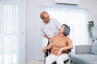 A contented senior couple and their in-home nurse. Elderly female in wheelchair with her young caregiver.