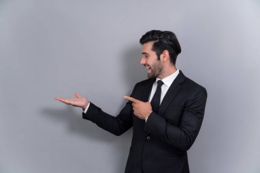 Resmi takım elbiseli kendine güvenen işadamı terfiyi ya da boş alanda reklamı işaret etmek için el ele tutuşuyor ve dışlanmış arka planda heyecanlı bir yüz ifadesi takınıyor. Coşkulu