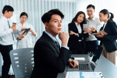 Portrait of focus young successful confident male manager, executive wearing business wear in harmony office arm crossed with blurred meeting background of colleagues, office worker.
