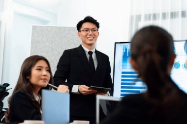 Confidence and asian businessman give presentation on financial analyzed by business intelligence in dashboard report to other people in board room meeting to promote harmony in workplace.