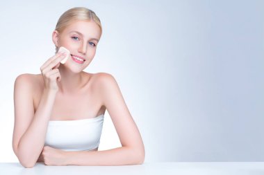 Personable beautiful natural soft makeup woman using powder puff for facial makeup concept. Cushion foundation applying on young girl face in isolated background.