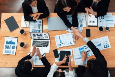 Top-view business team of financial data analysis meeting with business intelligence, report paper and dashboard on laptop for marketing strategy. Business people working together in office of harmony