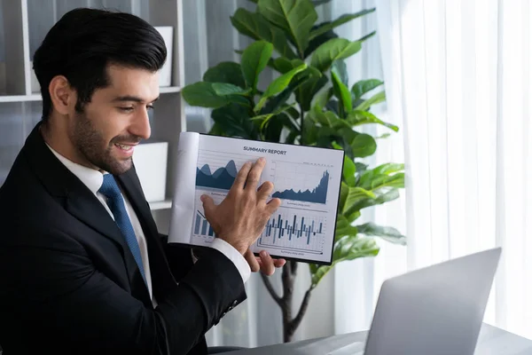 Professional businessman in black suit, present financial data or BI paper via laptop during online meeting. Remote work concept with virtual meeting presentation of effectiveness remote work. Fervent