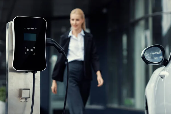 Focus Public Charging Station Electric Car Blurred Progressive Businesswoman Walking — Foto Stock