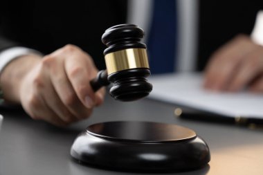 Siyah ahşap tokmağı kavrayıp kütüphanedeki ya da mahkeme salonundaki bulanık hakimin yargı sisteminin hukuk sistemi kavramı olarak çıkardığı sesi bastırmaya odaklanın. Eşitlik