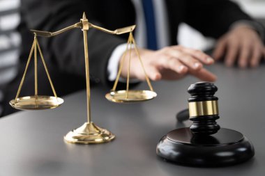 Hukuk bürosundaki masabaşında çalışan avukatın bulanık arka planına odaklan. Gavel, kanun koyucu ve avukatın adil ve eşit karar vermesi için çekiç. Eşitlik