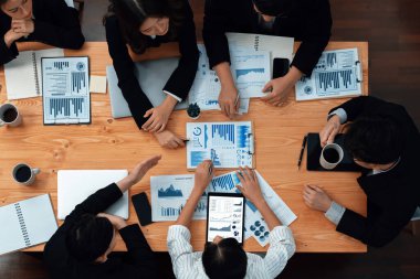 Top-view business team of financial data analysis meeting with business intelligence, report paper and dashboard on laptop for marketing strategy. Business people working together in office of harmony