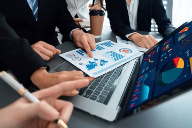 Business team analyze business analytic or business intelligence dashboard on laptop screen show graph and chart with statistic in harmony office. Analyst team meeting researching, planning strategy.