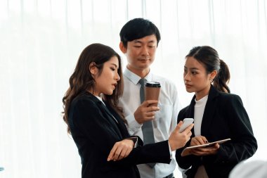 Mentor, manager with coffee advice younger colleagues in workplace. Businesspeople discussing or planning financial project strategy, talking together for harmony and strong teamwork in office concept