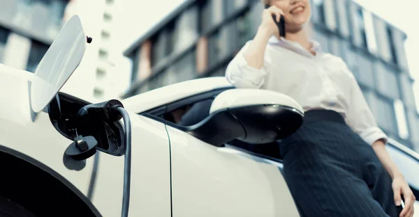 Focus Charging Electric Car Charger Charging Station Blur Businesswoman Talking — Stockfoto