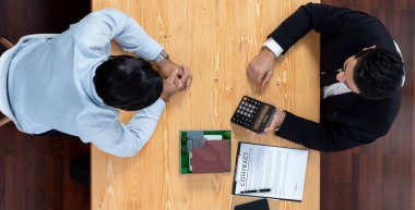 Üst düzey emlakçı vergi ve faizi hesaplar, ev kredisi ve emlak alımı için müşteriyle mülkiyet süresi ve sigorta anlaşmasını tartışır. Yatırım bütçesinin mali danışmanı. Coşkulu