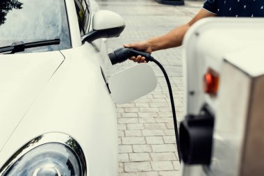 Gelişen el kavramı, evdeki elektrikli aracın bataryasına emisyonsuz güç bağlantısı sağlar. Elektrikli araç elektrik istasyonundan EV araba aküsüne kabloyla şarj oluyor.