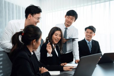 Harmony in office concept as business people analyzing dashboard paper together in workplace. Young colleagues give ideas at manager desk for discussion or strategy planning about project.