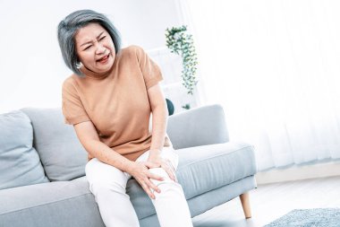 An agonizing elderly woman is experiencing chest pain. Medical attention, medical service for seniors.