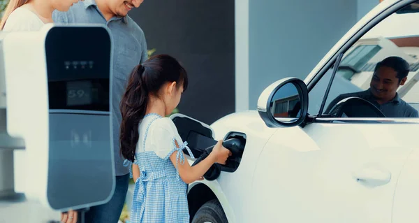 Progressive Young Parents Daughter Electric Vehicle Home Charging Station Green — Stok fotoğraf