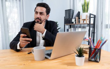 Modern ofis masasındaki modern profesyonel iş adamı çalışmak ve notlar yazmak için dizüstü bilgisayar kullanıyor. Ofisinde bilgisayar defteri üzerinde çalışan çalışkan bir ofis çalışanı. coşkulu