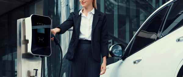 Προοδευτική Επιχειρηματίας Φορώντας Κοστούμι Ηλεκτρικό Αυτοκίνητο Επαναφόρτιση Στο Δημόσιο Χώρο — Φωτογραφία Αρχείου