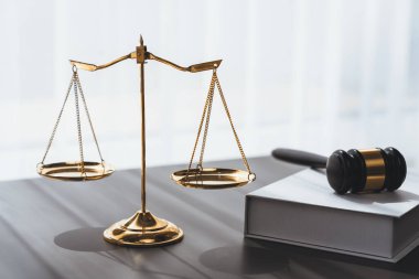 Adaleti ve hukuki otoriteyi temsil eden, altın dengeli ölçeği temsil eden ve avukatlık arka planında hukuk kitabı olan tokmağı, eşitlik ve adil yargı kavramını yansıtan. denge