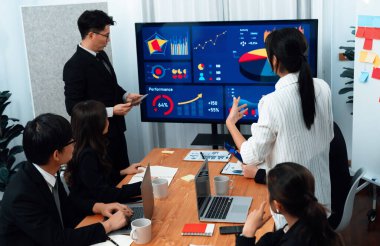 Confidence and asian businessman give presentation on financial analyzed by business intelligence in dashboard report to other people in board room meeting to promote harmony in workplace.