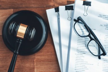 Closeup top view black wooden gavel hammer and legal document on wooden office desk background as justice and legal system for lawyer and judge, Legal authority and fairness in trials. equility clipart