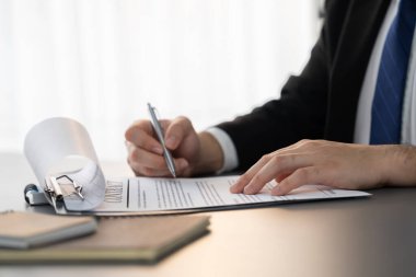 İş adamı sözleşme kağıtlarını ya da iş hukukunu güven ve profesyonellikle imzalar. Resmi iş anlaşması için şirket toplantısında el ele tutuşmak. Eşitlik