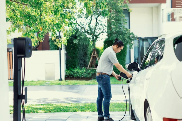 Progressive Asian Man Install Cable Plug His Electric Car Home — ストック写真
