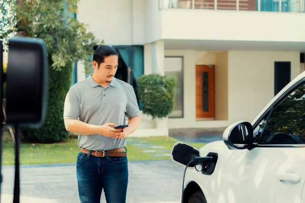 Progressive Asian Man Install Cable Plug His Electric Car Home — Foto Stock