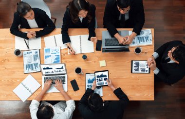 Top-view business team of financial data analysis meeting with business intelligence, report paper and dashboard on laptop for marketing strategy. Business people working together in office of harmony