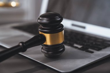 Adalet ve hukuki otoriteyi temsil eden, altın dengeli ölçek ve hukuk bürosunda dizüstü bilgisayarlı tokmak, avukat ve hakimin eşitlik ve adil yargılama kavramını yansıtıyor. denge