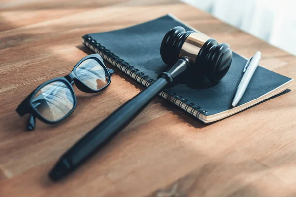 トップ表示を閉じます弁護士や裁判官のための司法制度として木製のオフィスの机の背景に本や眼鏡を持つ黒い木製のギャベルハンマー 裁判で権威と公平性を象徴 公平性 — ストック写真