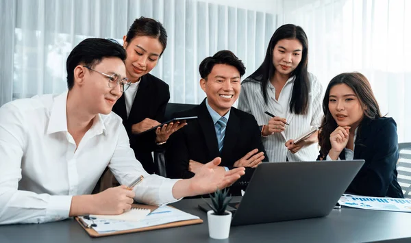 stock image Harmony in office concept as business people analyzing dashboard paper together in workplace. Young colleagues give ideas at manager desk for discussion or strategy planning about project.