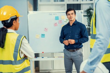 A team of investor and competent engineers brainstorming on the whiteboard to find new ideas and making plans. The idea of a team gather ideas together.