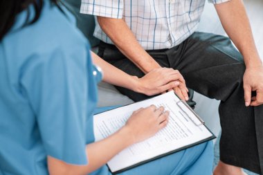 Senior man feeling contented as his caregiver provides him with good news about his health at medical consultation.
